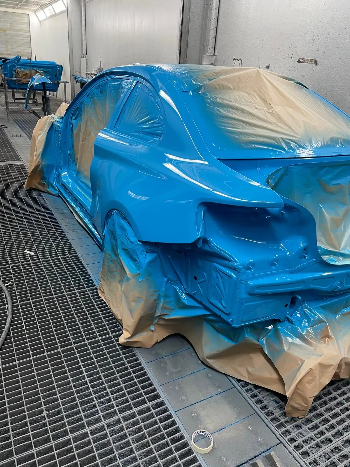 Blau lackiertes Fahrzeug in der Lackierkabine